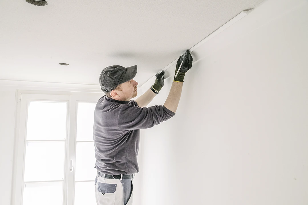 Ein Mitarbeiter von Malzeit bringt Stuckleisten an